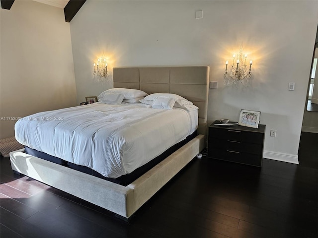 bedroom with dark wood-style floors, baseboards, and a chandelier