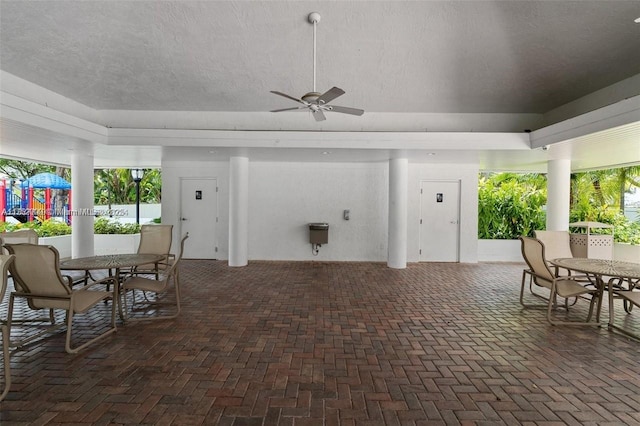 view of patio featuring playground community, outdoor dining area, and a ceiling fan