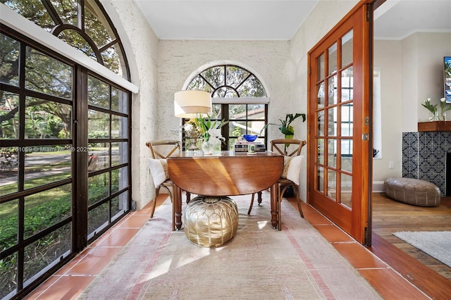 interior space featuring crown molding, french doors, light wood-type flooring, and baseboards