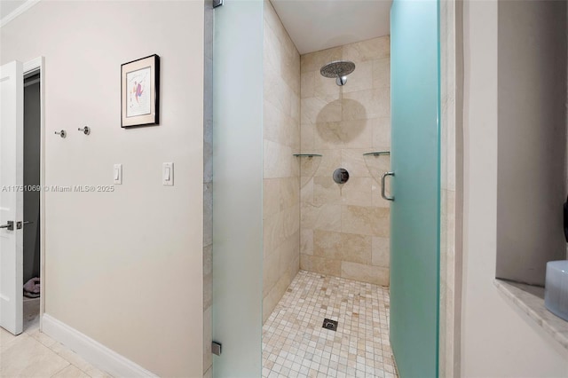 bathroom featuring a shower stall and baseboards