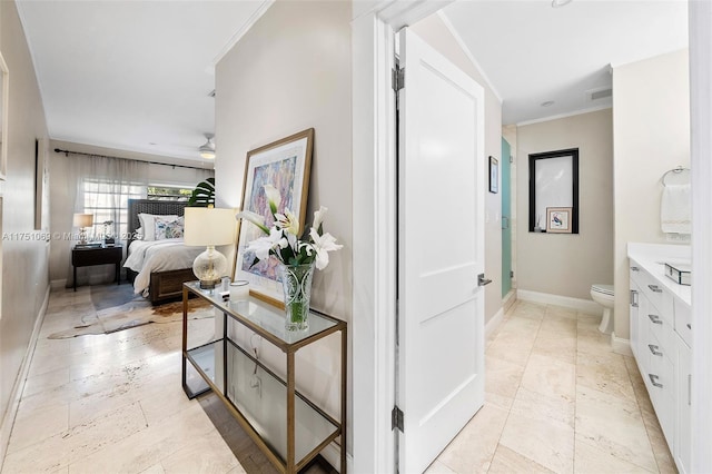 hallway featuring baseboards, visible vents, and ornamental molding