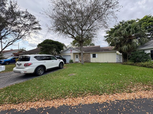 view of front facade featuring aphalt driveway, an attached garage, board and batten siding, and a front lawn