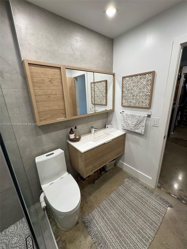 bathroom featuring toilet, baseboards, and vanity