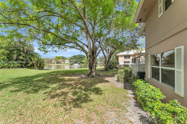 view of yard featuring a water view and central AC unit