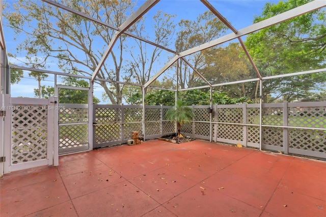 view of patio with glass enclosure and fence