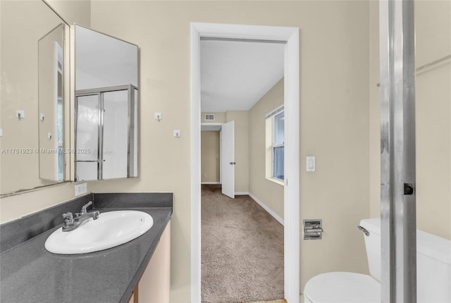 bathroom featuring visible vents, toilet, an enclosed shower, vanity, and baseboards