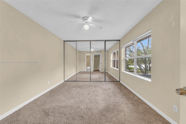 unfurnished bedroom with carpet, baseboards, and a textured ceiling