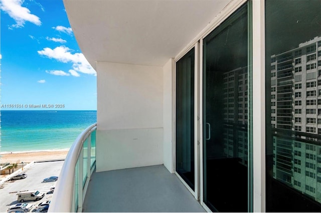 balcony featuring a water view and a view of the beach