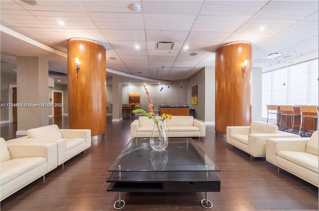 living room featuring visible vents, wood finished floors, baseboards, and a drop ceiling