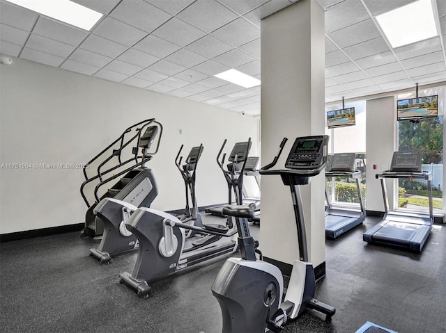 gym featuring a drop ceiling, baseboards, and floor to ceiling windows