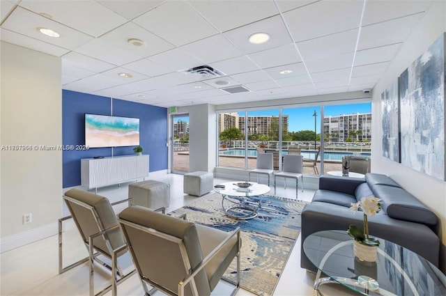 living area with recessed lighting, a paneled ceiling, visible vents, and baseboards