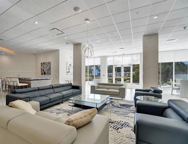 living room with visible vents, a wall of windows, and a paneled ceiling