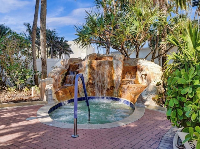 view of swimming pool with an in ground hot tub and fence