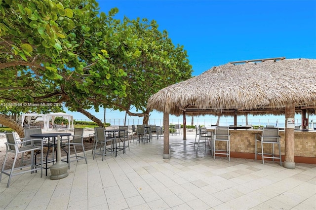 view of patio / terrace featuring outdoor dry bar and a water view