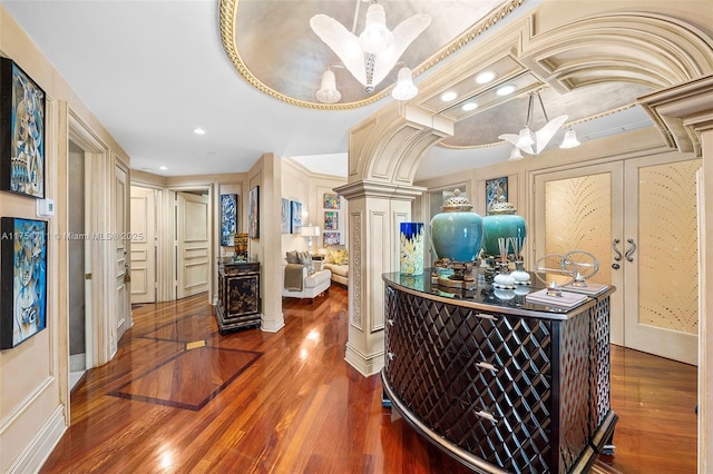 hall with ornate columns, recessed lighting, wood finished floors, and french doors