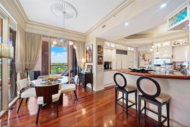 dining space with visible vents, ornamental molding, and dark wood-style flooring