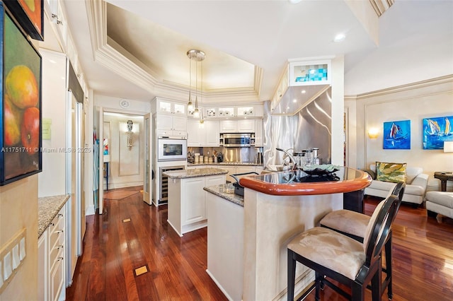 kitchen with glass insert cabinets, a center island, decorative light fixtures, and appliances with stainless steel finishes