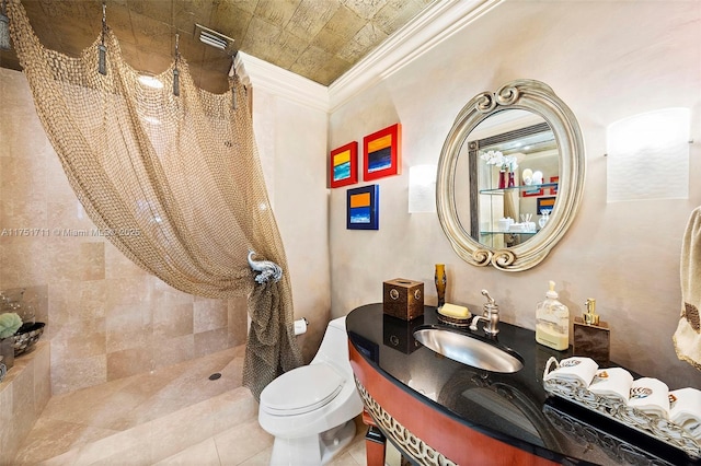 bathroom with ornamental molding, vanity, toilet, and tile patterned floors