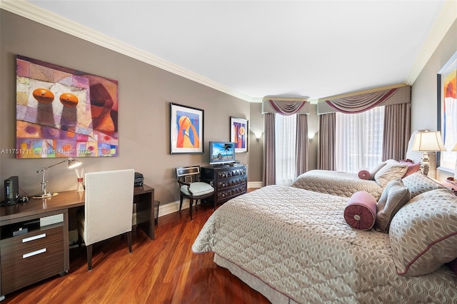 bedroom with baseboards, crown molding, and wood finished floors