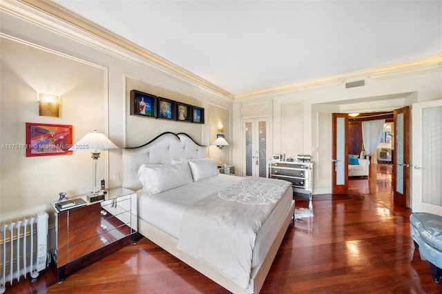 bedroom featuring wood finished floors, visible vents, ornamental molding, french doors, and radiator heating unit