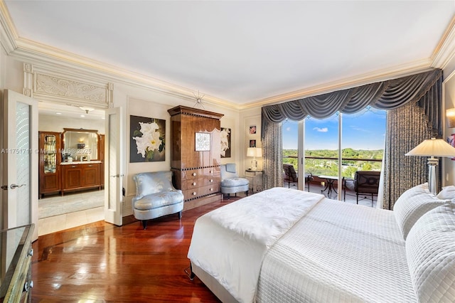 bedroom with ornamental molding, dark wood finished floors, and access to exterior