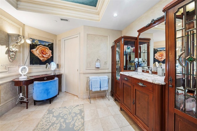 interior space featuring a tray ceiling, crown molding, visible vents, vanity, and tile patterned floors