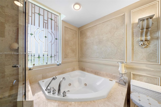 full bathroom featuring a whirlpool tub and a shower stall