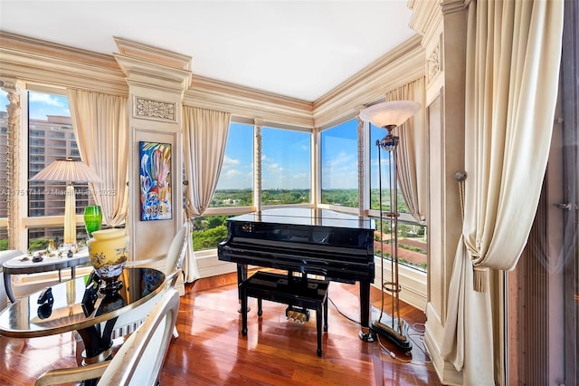 living area with a wealth of natural light, crown molding, and wood finished floors