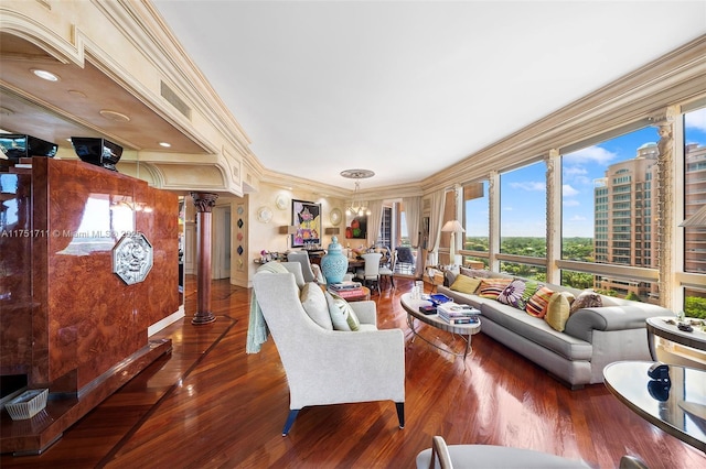 living area with a view of city, decorative columns, visible vents, ornamental molding, and wood finished floors