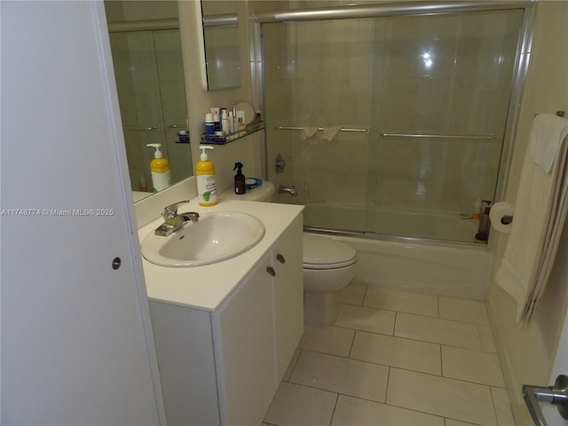 bathroom with enclosed tub / shower combo, toilet, tile patterned flooring, and vanity