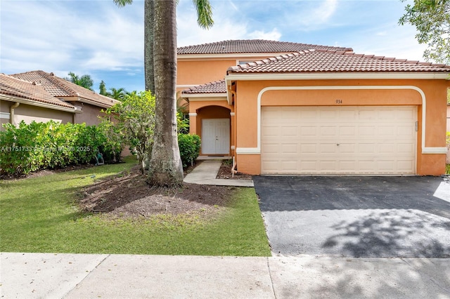 mediterranean / spanish home with a garage, a tile roof, driveway, and stucco siding