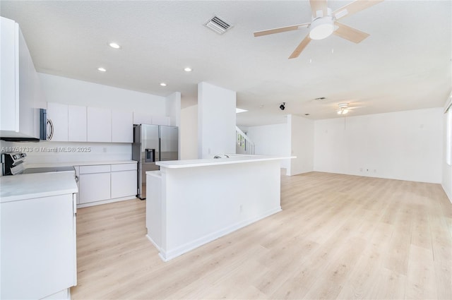 kitchen featuring a ceiling fan, visible vents, light wood-type flooring, and stainless steel appliances