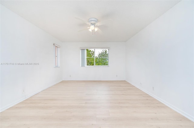 unfurnished room featuring light wood-type flooring, a ceiling fan, and baseboards