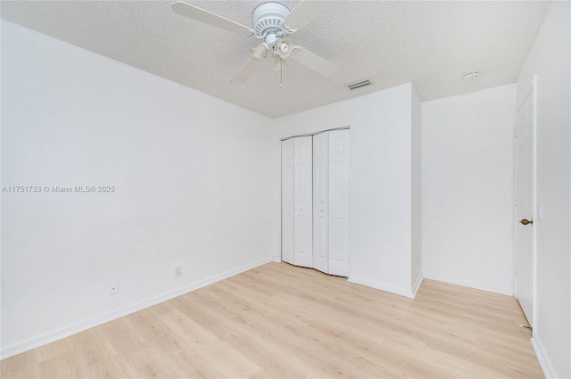 unfurnished bedroom with visible vents, baseboards, a closet, and light wood-style floors