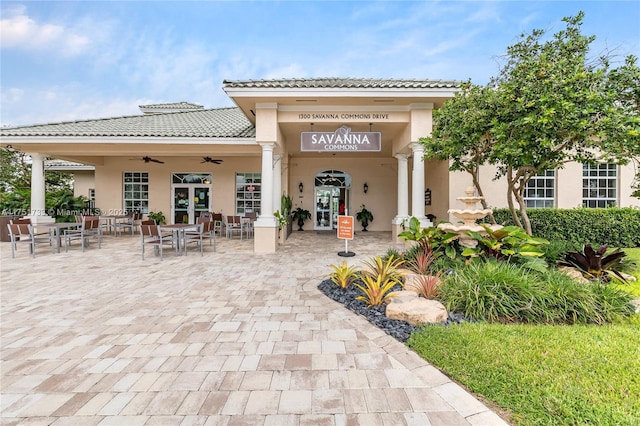 exterior space featuring french doors, stucco siding, a ceiling fan, and a tiled roof