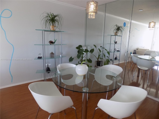 dining space with baseboards and wood finished floors