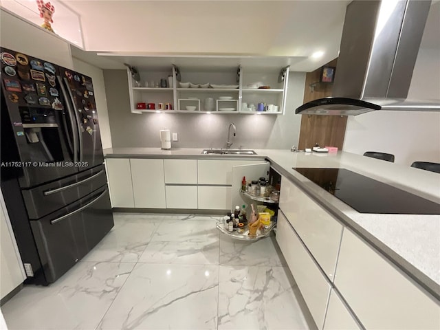 kitchen with island range hood, white cabinets, marble finish floor, black appliances, and a sink