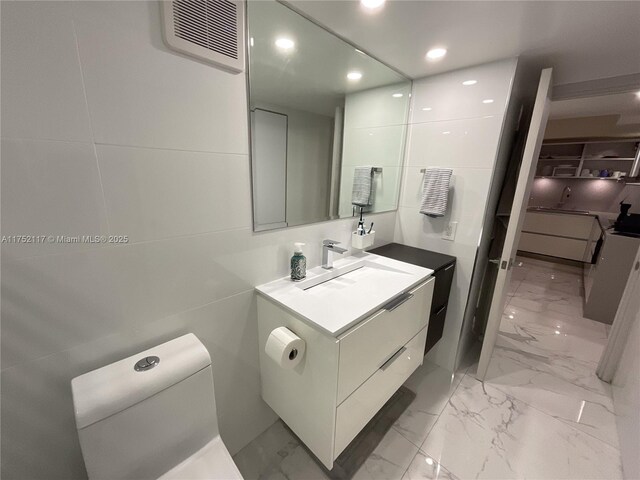 1301 NE Miami Gardens Dr Unit 501W, Miami, FL 33179 - bathroom featuring marble finish floor, visible vents, tile walls, and vanity