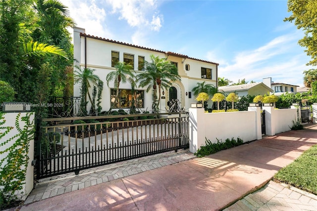 view of front facade with a fenced front yard, a gate, and stucco siding