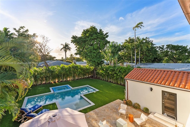 view of pool featuring a fenced backyard, a lawn, a patio, and an in ground hot tub