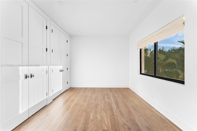 unfurnished bedroom featuring light wood-style flooring and baseboards