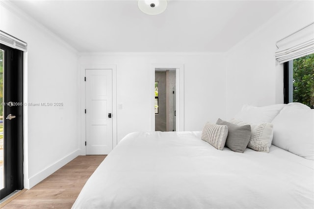 bedroom with light wood-type flooring, baseboards, and crown molding