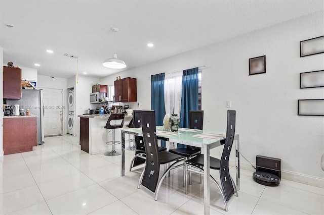 dining space with recessed lighting, stacked washer / drying machine, and light tile patterned floors