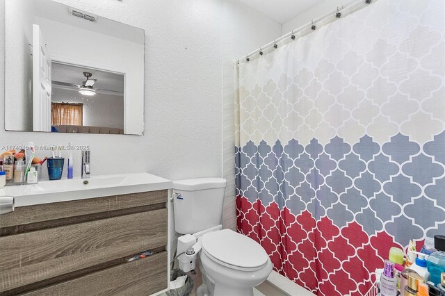 full bath with vanity, visible vents, curtained shower, toilet, and a textured wall