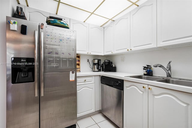 kitchen with light tile patterned flooring, a sink, white cabinetry, light countertops, and appliances with stainless steel finishes