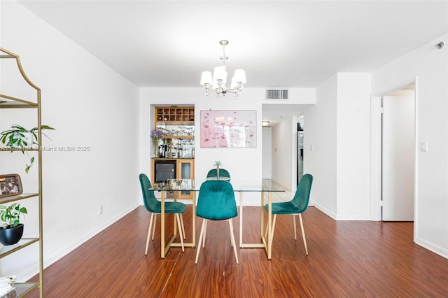 dining room with baseboards, visible vents, dark wood finished floors, and a chandelier