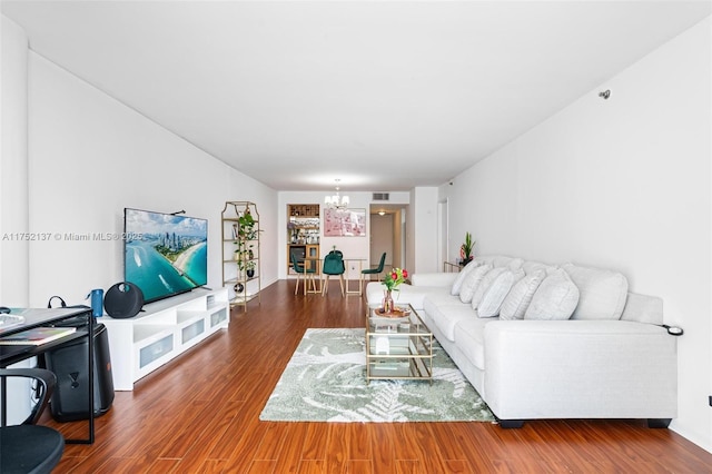 living room featuring visible vents, a notable chandelier, and wood finished floors