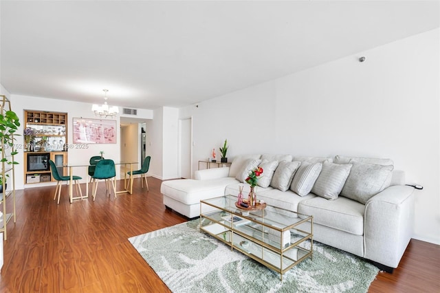 living area featuring a chandelier, wood finished floors, and visible vents