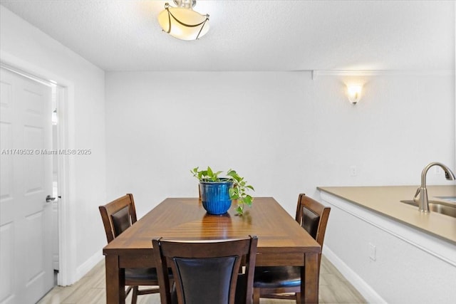 dining area featuring baseboards and a textured ceiling