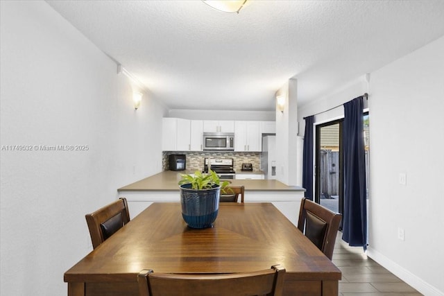 dining space with a textured ceiling and baseboards